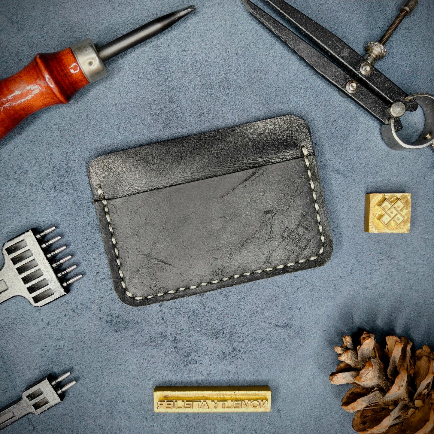 Back view of The Houdini minimalist leather card holder in horizontal configuration by Novelty Atelier – features a clean, functional layout with the design logo subtly stamped into black full-grain leather. Accented with off-white saddle stitching for a timeless aesthetic.