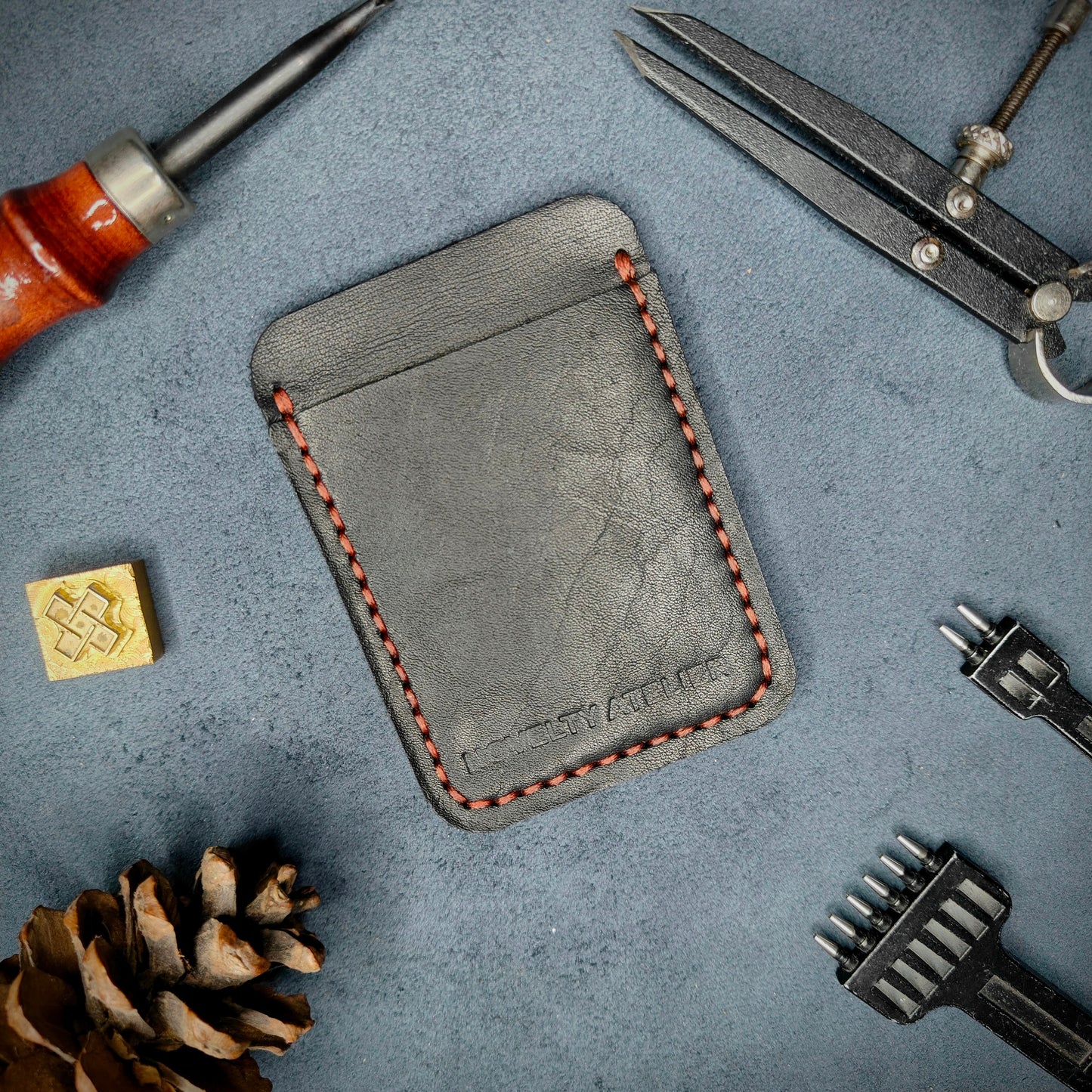 Front view of The Houdini minimalist card holder in vertical configuration by Novelty Atelier – handcrafted from Black ethically sourced full-grain leather with contrasting red saddle stitching. Features the “Novelty Atelier” brand name cleanly embossed on the front. Perfectly balanced minimalist wallet design tailored for modern EDC enthusiasts who value craftsmanship and brand integrity.