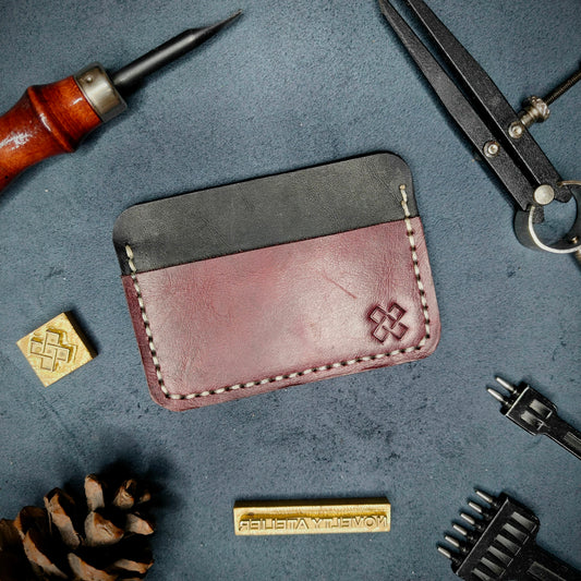 Back view of The Houdini minimalist leather card holder in horizontal configuration by Novelty Atelier – features a clean, functional layout with the design logo subtly stamped into Purple full-grain leather. Accented with off-white saddle stitching for a timeless aesthetic.

