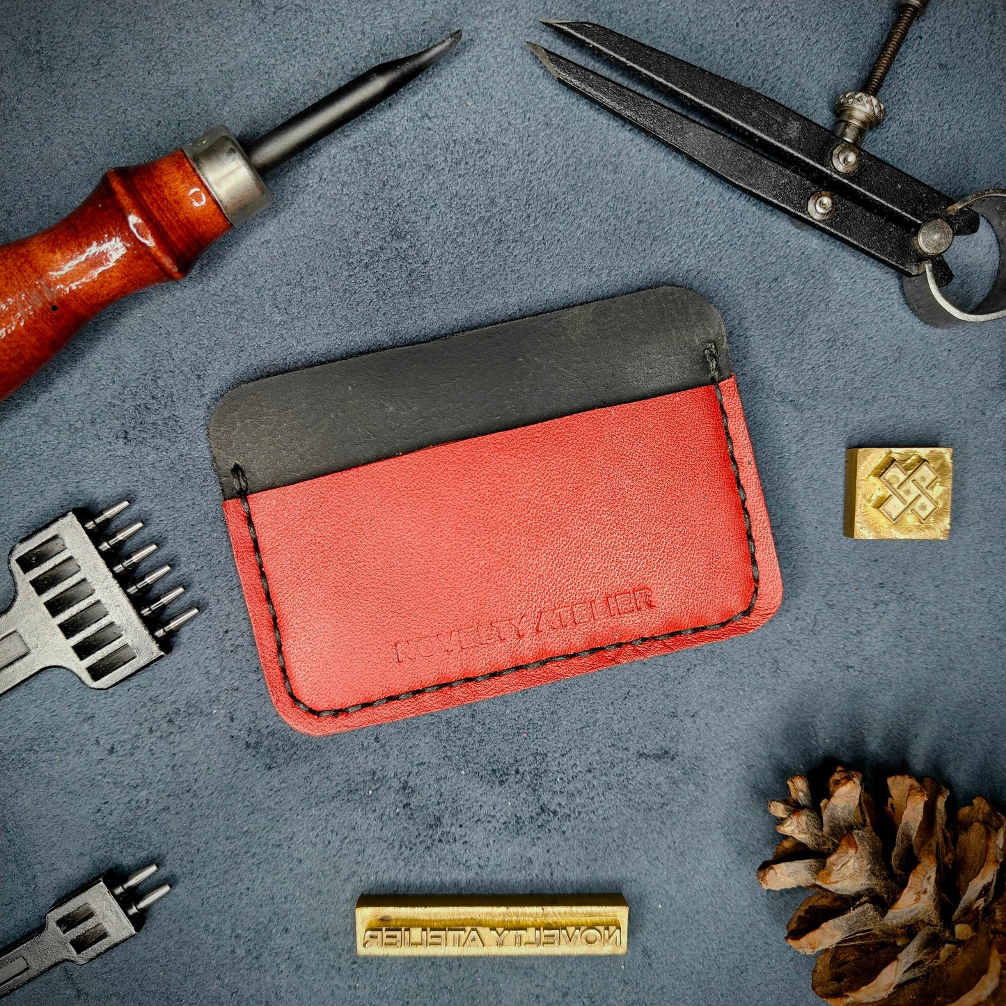 Front view of The Houdini minimalist card holder in horizontal configuration by Novelty Atelier – handcrafted from Black and Red ethically sourced full-grain leather with crisp Black saddle stitching. Features the “Novelty Atelier” brand name cleanly embossed on the front. Perfectly balanced minimalist wallet design tailored for modern EDC enthusiasts who value craftsmanship and brand integrity.
