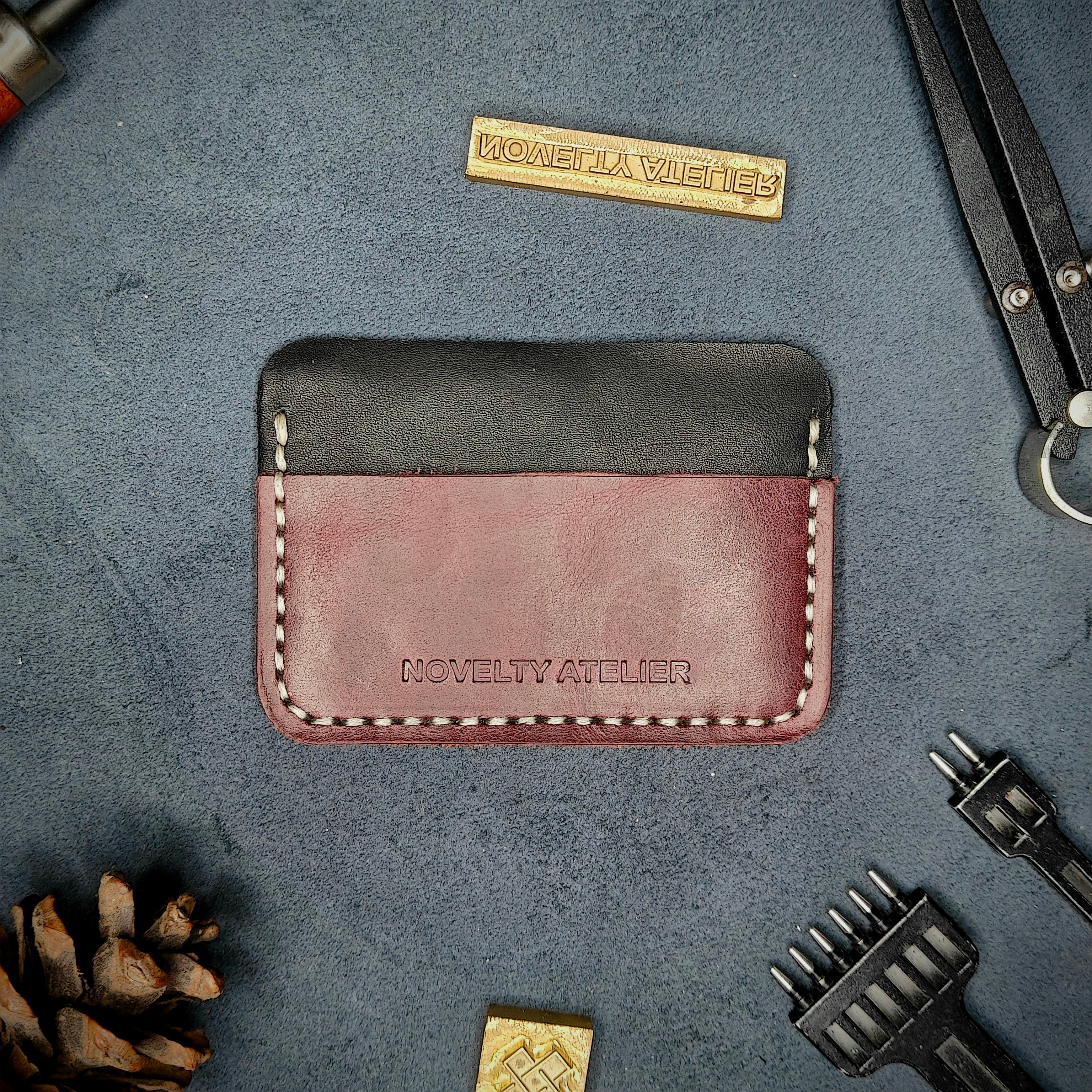 Home page Banner -The Houdini minimalist card holder - black and purple leather with off-white thread - showing a detailed picture of the brand Novelty Atelier - with all tools for aesthetics