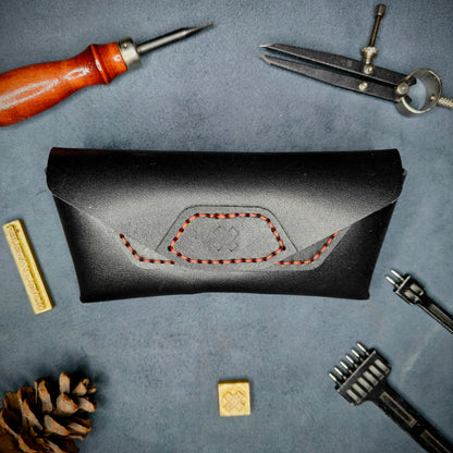 The Hustler - Sunglass case black full grain leather - closed with magnetic snap Detailed picture showing the logo with tools surrounding for aesthetics